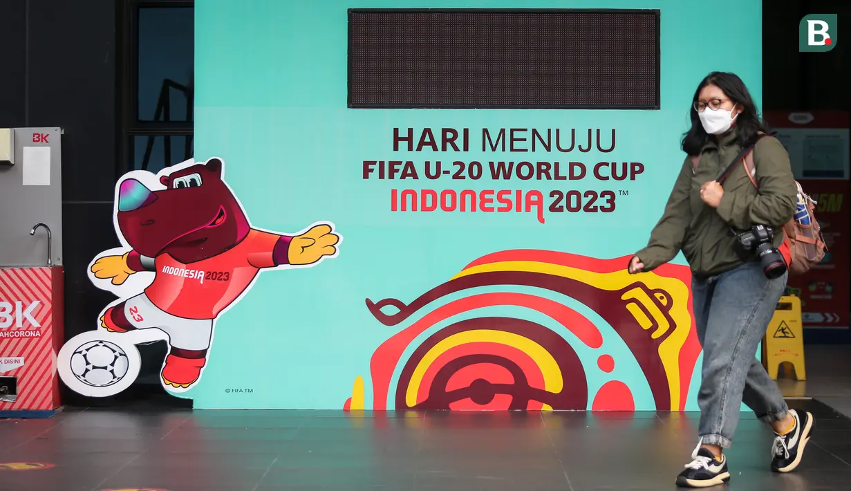 Seorang wartawan melewati papan elektronik hitung mundur yang terletak di GBK Arena, Senayan, Jakarta, Kamis (30/03/2023) sebagai respon pembatalan Indonesia sebagai tuan rumah Piala Dunia U-20 2023 oleh FIFA. (Bola.com/Bagaskara Lazuardi)