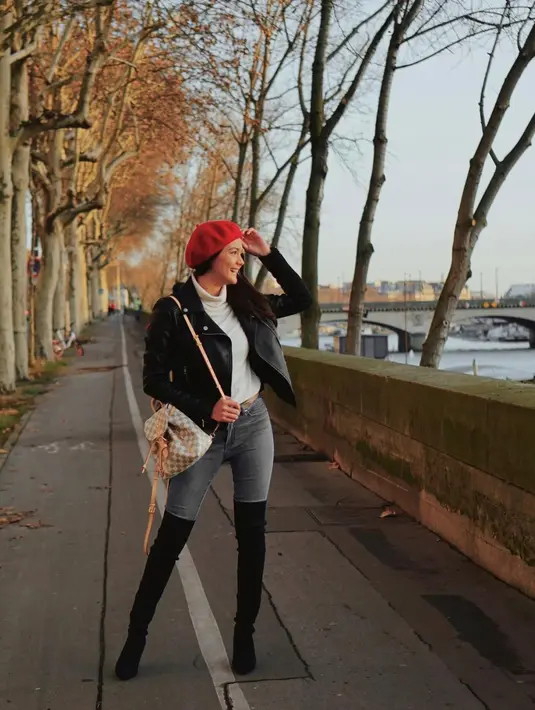 Jaket leather, sepatu boots selutut dan topi beret wol merupakan kombinasi outfit yang tepat saat kamu berlibur ke Paris. (instagram/amandarawles)