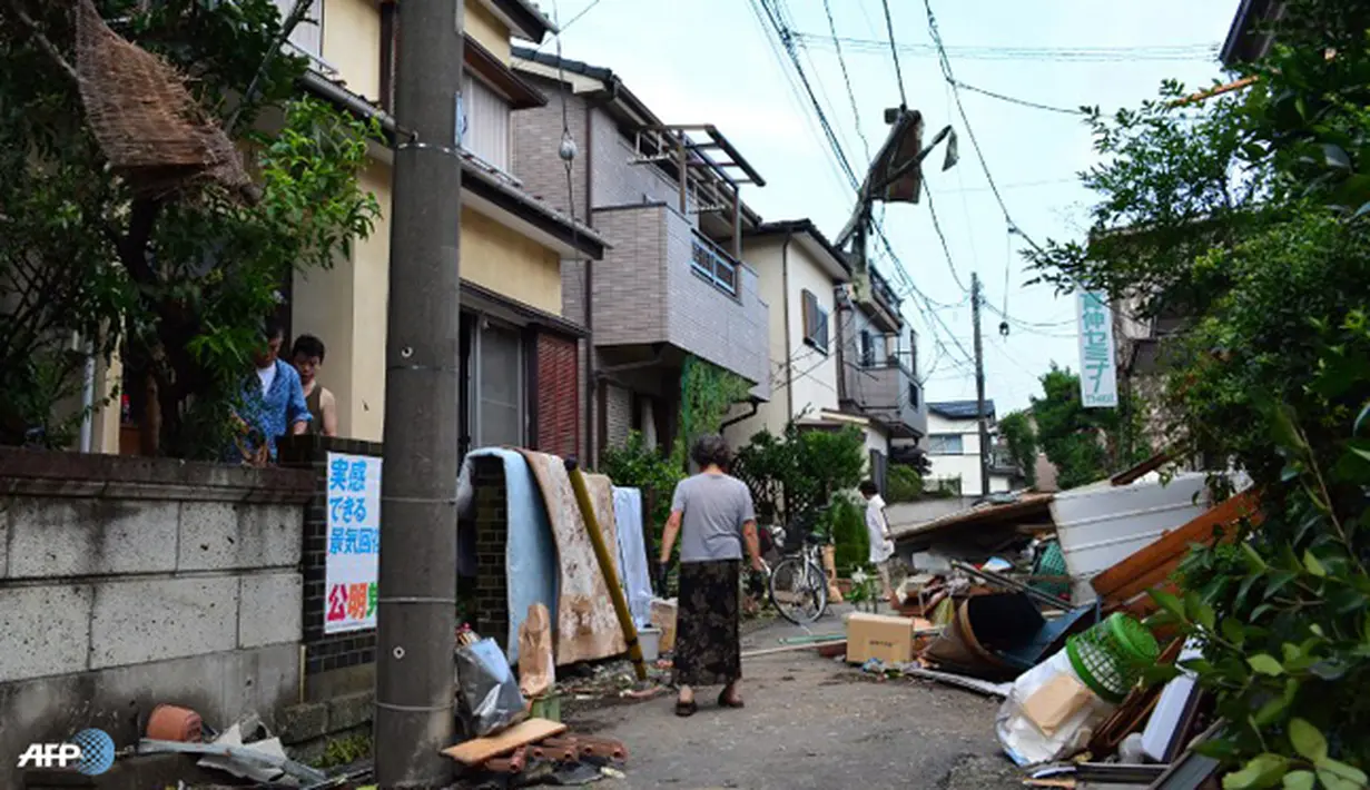 Warga melihat jalanan mereka ditutupi dengan puing-puing berserakan. Usai tornado, warga setempat memeriksa rumah-rumah mereka yang rusak. (AFP/Kazuhiro Nogi/wwn)