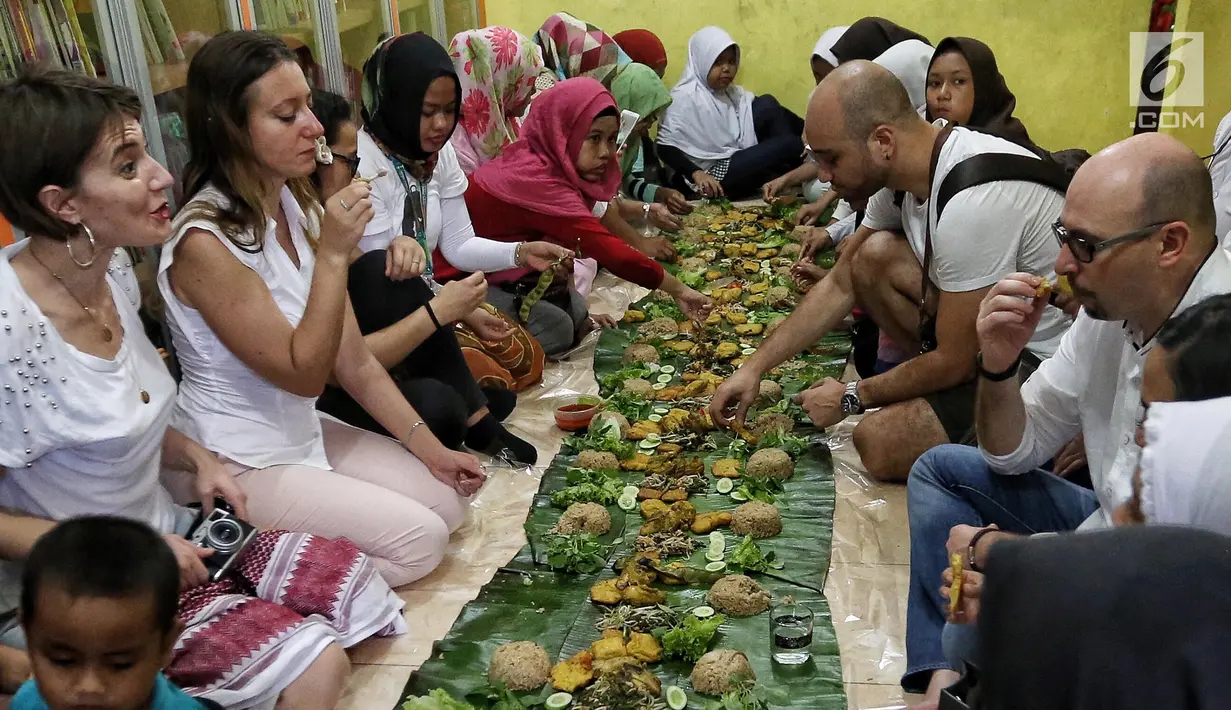 Sejumlah anak yatim, kaum dhuafa bersama lima warga negara asing (WNA) menikmati makanan nasi liwet sambil lesehan di Rumah Amalia, Ciledug, Kota Tangerang, Sabtu (3/3). Mereka juga berbagi cerita dan pengalaman di negaranya. (Liputan6.com/Fery Pradolo)