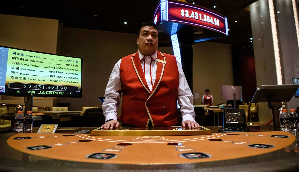 Anggota staf mempersiapkan meja kasino di resor MGM Cotai di Macau (13/2). MGM China membuka resor mega multi-miliar dolar baru di strip Cotai yang mewah di Macau pada tanggal 13 Februari. (AFP Photo/Anthony Wallace)