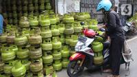 Warga mengangkut tabung gas LPG 3 kilogram (kg) dengan sepeda motor di Jakarta, Rabu (16/12/2020). PT Pertamina (Persero) memperkirakan kebutuhan gas elpiji 3 kg naik menjadi 7,50 juta metrik ton pada 2021. (Liputan6.com/Angga Yuniar)