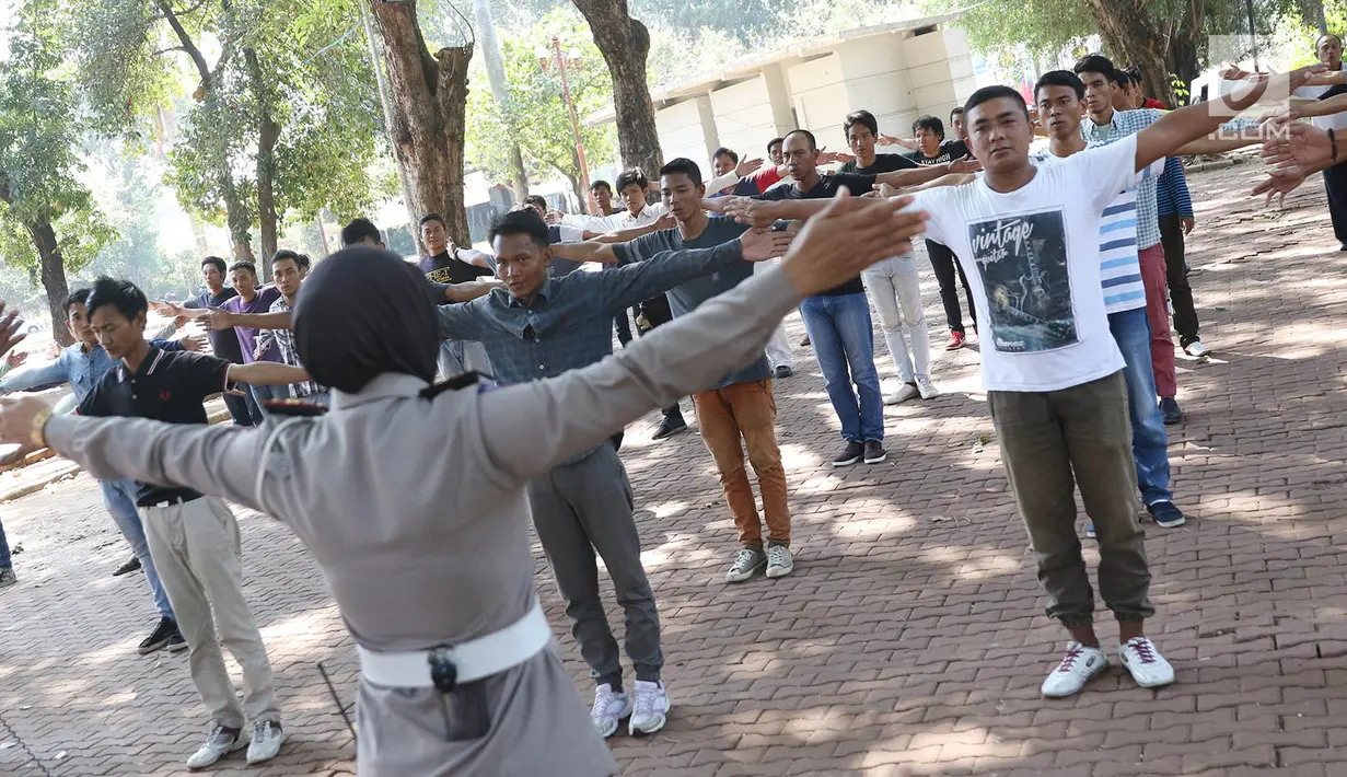 Calon Sukarelawan Pengatur Lalu Lintas (Supeltas) atau 'Pak Ogah' berlatih gerakan pengaturan lalu lintas di Lapangan Banteng, Jakarta, Kamis (24/8). Mereka diwajibkan menjalani serangkaian pelatihan selama lima hari. (Liputan6.com/Immanuel Antonius)