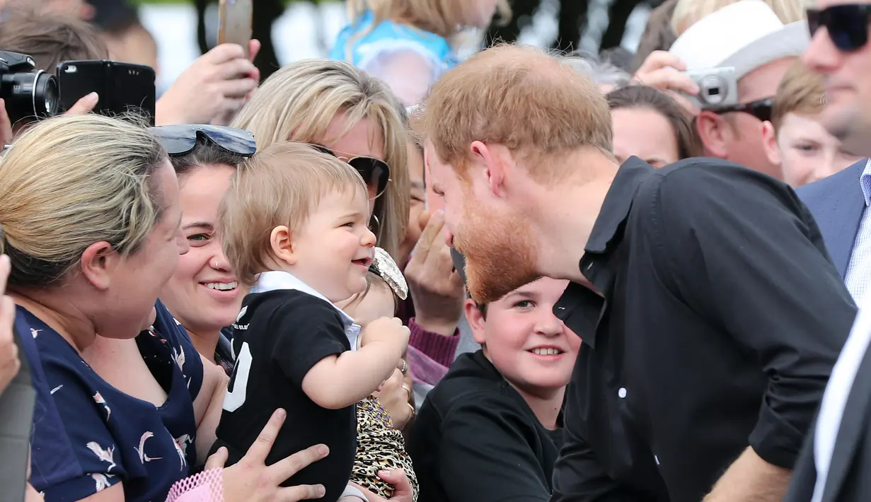 <p>Pangeran Harry menyapa anak kecil saat berjalan di Taman Pemerintah Rotorua, Selandia Baru, Rabu (31/10). Pangeran Harry dan Meghan Markle sedang dalam tur tiga minggu di Australia, Selandia Baru, Tonga, dan Fiji. (Michael Bradley/Pool/AFP)</p>