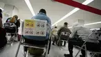 Penumpang duduk dan menunggu giliran selama proses karantina pencegahan virus corona setelah mendarat di Bandara Internasional Narita di Narita, timur Tokyo, Jepang (2/12/2021). Kasus pertama varian baru Covid-19 Omicron terdeteksi di Bandara Narita, Jepang.  (AP Photo/Hiro Komae)