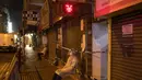 Petugas kesehatan mengenakan APD berjaga di area tertutup di distrik Jordan, di Hong Kong, Minggu (24/1/2021). Kawasan tersebut telah mengkonfirmasi 162 kasus COVID-19 yang dikonfirmasi bulan ini. (AP Photo/ Kin Cheung)