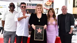 Penyanyi dan pembawa acara talk show Kelly Clarkson (tengah) memegang replika bintang Hollywood Walk of Fame bersama mantan juri American Idol, Randy Jackson (kiri), Simon Cowell (kedua kiri), Paula Abdul (kedua kanan), dan direktur musik Jason Halbert (kanan) di Los Angeles, Amerika Serikat, 19 September 2022. Setelah 20 tahun memenangkan musim perdana acara kompetisi menyanyi, Kelly Clarkson akhirnya diakui sebagai bintang di Hollywood Walk of Fame. (Photo by Jordan Strauss/Invision/AP)