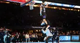 Mac McClung dari Osceola Magic melakukan slam dunk dengan melompati dua orang saat kontes Slam Dunk pada NBA All Star 2024 di Lucas Oil Stadium, Indianapolis, AS, Minggu (18/02/2024).  (AFP/Getty Images/Stacy Revere)