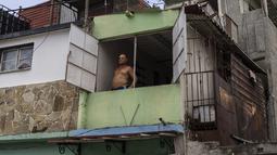 Seorang pria melihat ke luar jendela saat pemadaman listrik pagi yang terprogram, di Regla, Kuba, Senin, 1 Agustus 2022. Pengumuman pemadaman listrik muncul saat negara tersebut berjuang dengan krisis energi; banyak bagian negara telah mengalami pemadaman listrik setiap hari. (AP Photo/Ramon Espinosa)