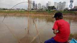 Warga mencari ikan dengan menggunakan jala di Banjir Kanal Barat, Tanah abang, Jakarta, Sabtu (4/1/2020). Debit air yang mulai surut di aliran tersebut dimanfaatkan warga untuk mencari ikan. (Liputan6.com/Angga Yuniar)