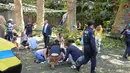 Warga menolong korban korban pohon tumbang di Funchal, Portugal (15/8). Sebuah pohon ek berusia 200 tahun tumbang dan menimpa kerumunan orang yang berada di sebuah alun-alun di wilayah sub-urban Funchal. (AFP Photo/Rui Silva)