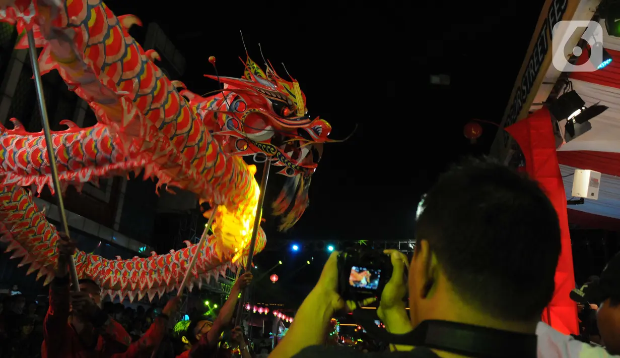 Warga menyaksikan pawai Bogor Street Festival Cap Go Meh (CGM) 2020 yang digelar di Jalan Surya Kencana, Kota Bogor, Jawa Barat, Sabtu (8/2/2020). Festival bertema "Ajang Budaya Pemersatu Bangsa" dimeriahkan 25 kelompok barongsai-liong dan beragam tarian daerah. (Liputan6.com/Helmi Fithriansyah)