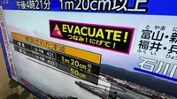 Peringatan tsunami ditayangkan di TV di Yokohama hari ini setelah gempa bumi di Laut Jepang. (AP)