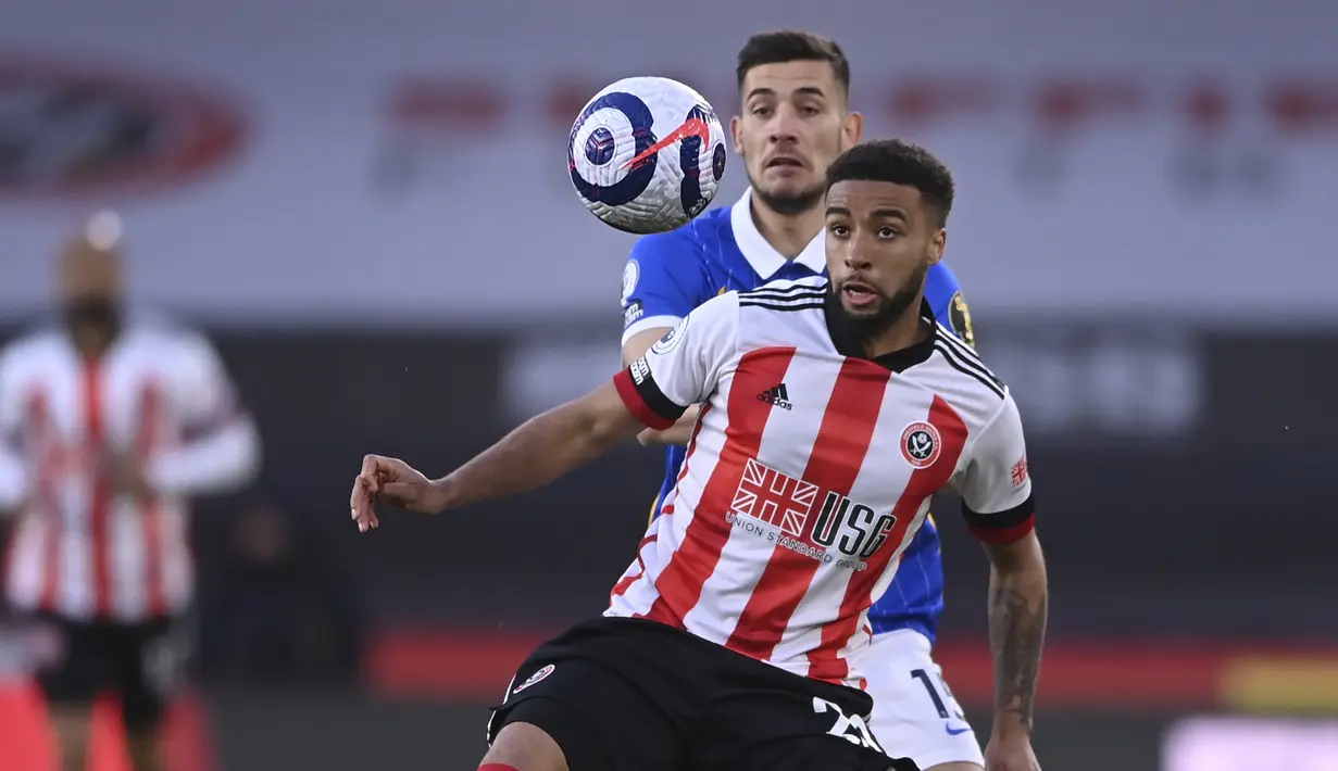 Bek Sheffield United, Jayden Bogle (depan) menguasai bola dibayangi gelandang Brighton and Hove Albion, Jakub Moder dalam laga lanjutan Liga Inggris 2020/2021 pekan ke-33 di Bramall Lane, Sheffield, Sabtu (24/4/2021). Brighton kalah 0-1 dari Sheffield United. (AP/Laurence Griffiths/Pool)