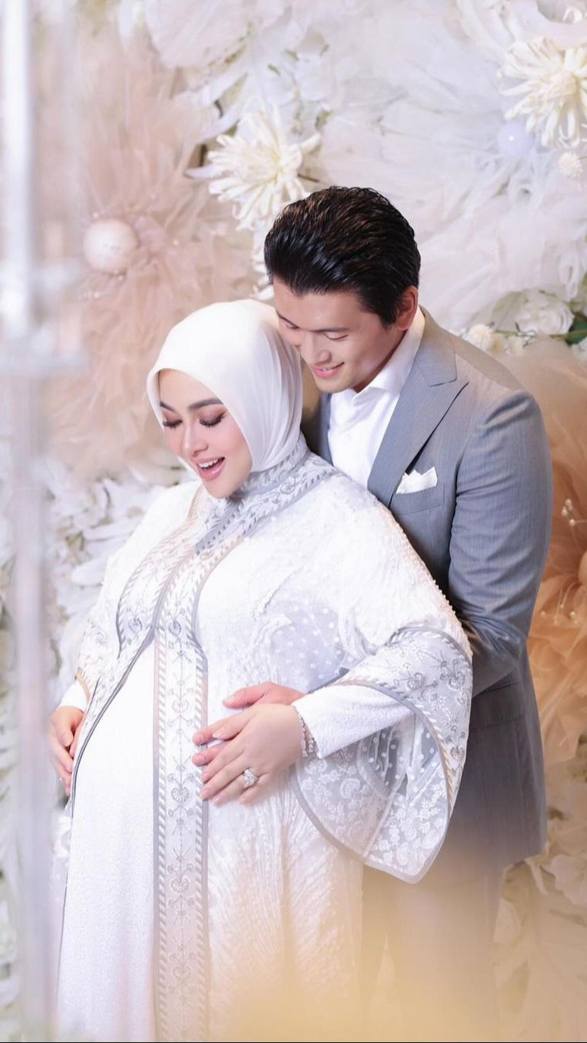 Sang suami, Reino Barack pun juga tampak gagah dengan pakaian jas abu-abu serta kemeja putih yang senada dengan pakaian Syahrini di acara tersebut.<br>