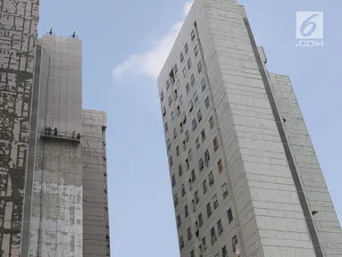 Pekerja mengecat dinding Rusun Jatinegara Barat di Jakarta, Minggu (6/8). Pengecatan dilakukan untuk memperbaiki sebagian besar dinding rusun yang mulai mengelupas agar menghindari kesan kumuh. (Liputan6.com/Immanuel Antonius)