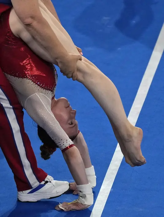 Viktoriia Listunova, dari Komite Olimpiade Rusia, melakukan peregangan sebelum tampil di lemari besi selama kualifikasi senam artistik putri di Olimpiade Musim Panas 2020 di Tokyo, Jepang, Minggu (25/7/2021). (AP Photo/Gregory Bull)