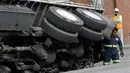 Petugas bersiap menderek truk yang terjebak di sebuah saluran pembuangan di San Francisco, AS, Jumat (5/5). Diduga karena muatan yang terlalu berat membuat bagian atas saluran pembuangan menjadi amblas. (AP Photo / Jeff Chiu)
