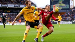 Pemain Wolverhampton Wanderers Craig Dawson (kiri) bertarung memperebutkan bola dengan pemain Liverpool Thiago Alcantara pada pertandingan sepak bola Liga Inggris di Stadion Molineux, Wolverhampton, Inggris, 4 Februari 2023. Wolverhampton Wanderers mengalahkan Liverpool dengan skor 3-0. (Barrington Coombs/PA via AP)