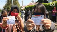 Warga mengurus Surat Izin Mengemudi (SIM) di mobil layanan SIM Keliling Masjid At-Tin, Jakarta Timur, Kamis (4/6/2020). Direktorat Lalu Lintas Polda Metro Jaya mengoperasikan kembali layanan mobil SIM Keliling untuk mengantisipasi antrean pemohon. (Liputan6.com/Herman Zakharia)
