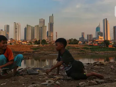 Anak anak bermain dengan latar gedung bertingkat di Jakarta, Jumat (15/12/2023). (Liputan6.com/Angga Yuniar)