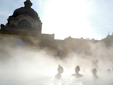 Para pengunjung berbincang sambil berendam di kolam relaksasi Szechenyi, di Budapest, Hongaria pada 15 Februari 2019. Szechenyi Thermal Bath adalah salah satu lokasi pemandian umum tertua dan terbesar di Budapest. (VALERY HACHE / AFP)