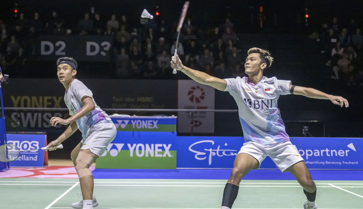 Pemain ganda putra Indonesia, Muhammad Shohibul Fikri (kanan) yang berpasangan dengan Bagas Maulana berusaha mengembalikan bola ke arah pasangan Inggris, Ben Lane/Sean Vendy pada laga final kejuaraan bulu tangkis Swiss Open 2024 di St. Jakobshalle, Basel, Swiss, Minggu (24/3/2024). Bagas/Fikri kalah dua gim langsung 22-24, 26-28 dan gagal menjadi juara. (Keystone via AP Photo/Georgios Kefalas)
