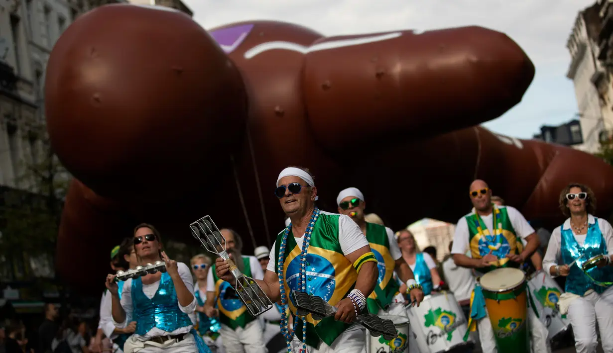 Marching band memainkan musik di depan balon raksasa berbentuk karakter tokoh komik selama parade Comic Strip Festival di Brussels, 15 September 2018. Tokoh komik terkenal dan karakter tokoh Belgia ditampilkan sepanjang jalan. (AP Photo/Francisco Seco)