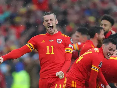 Penyerang Wales, Wales Gareth Bale dan rekan-rekannya melakukan selebrasi usai berhasil lolos ke Piala Dunia 2022 setelah kalahkan Ukraina dalam pertandingan playoff kualifikasi Piala Dunia di Stadion Cardiff City, Cardiff, Wales, Minggu (5/6/2022). Wales menang atas Ukraina dengan skor tipis 1-0. (AFP Photo/Geoff Caddick)