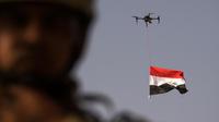 Sebuah drone mengibarkan bendera nasional Irak saat perayaan keberhasilan menyingkirkan militan ISIS dari Kota Tua Mosul, Minggu (9/7). Irak memulai pertempuran merebut Mosul pada Oktober lalu dengan dukungan dari koalisi pimpinan AS. (FADEL SENNA/AFP)
