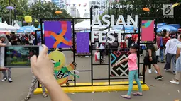 Dua anak foto bersama di landmark Asian Festival 2018 di kawasan Gelora Bung Karno Senayan, Jakarta, Minggu (2/9). Mereka memanfaatkan waktu sambil menunggu Closing Ceremony Asian Games 2018. (Liputan6.com/Fery Pradolo)