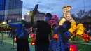 Orang-orang berswafoto di depan lentera yang menyala selama Festival Pertengahan Musim Gugur di taman Victoria di Hong Kong, Selasa (21/9/2021).  Festival ini didatangi keluarga dan teman Tionghoa untuk berkumpul makan kue bulan China dan pomelo bersama-sama. (AP Photo/Vincent Yu)