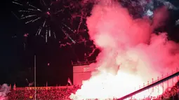 Para suporter menyalakan flare yang membuat laga leg kedua final Pegadaian Liga 2 2023/2024 dihentikan untuk keunggulan PSBS Biak 3-0 atas Semen Padang di Stadion GOR Haji Agus Salim, Padang, Sabtu (9/3/2024). (Bola.com/Bagaskara Lazuardi)