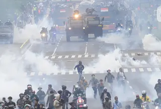 Petugas Brimob Polri menembakkan gas air mata untuk membubarkan massa usai terjadi lemparan batu di Jalan MH Thamrin, Jakarta, Selas (13/10/2020). Massa pengunjuk rasa yang menolak Omnibus Law akhirnya dibubarkan aparat. (merdeka.com/Arie Basuki)