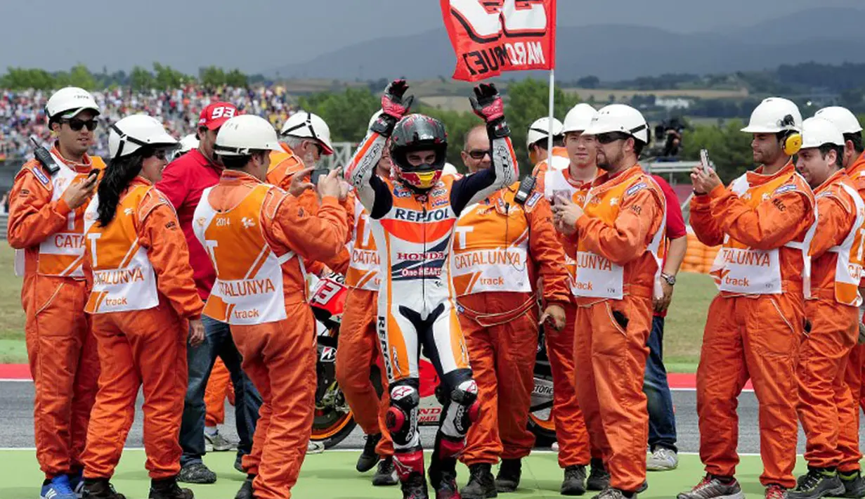 Kemenangan pembalap Spanyol. Marc Marquez, disambut beberapa petugas lapangan Sirkuit Katalunya, Montmelo, Barcelona, (15/6/2014). (REUTERS/Josep Lago)