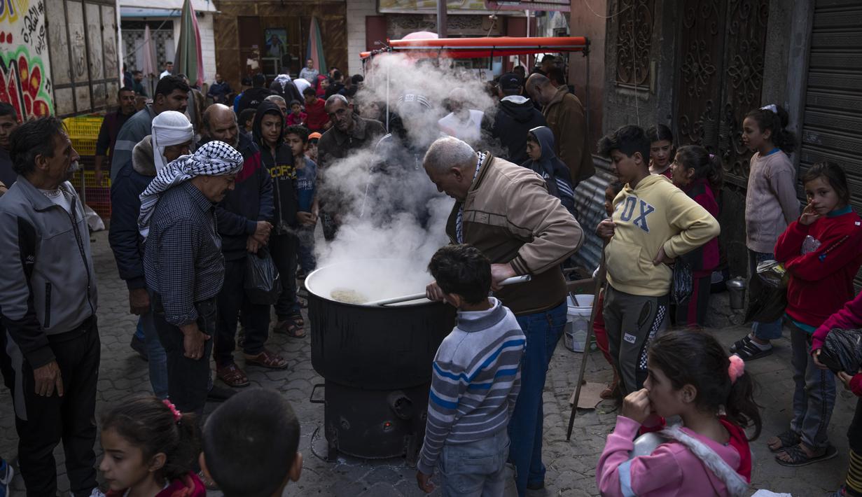 Walid Hattab memasak sup gandum panas dan bubur sebelum berbuka puasa selama bulan suci Ramadhan di lingkungan Shijaiyah di Kota Gaza, Minggu, 26 Maret 2023. (AP Photo/Fatima Shbair)