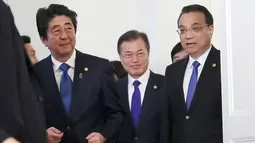 Perdana Menteri Jepang Shinzo Abe, Presiden Korea Selatan Moon Jae-in, Perdana Menteri China Li Keqiang berjalan bersama usai melakukan pertemuan tingga negara di Tokyo, Jepang (9/5). (AP Photo/Eugene Hoshiko, Pool)