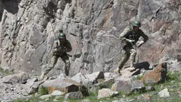 Pasukan menuruni tebing saat ikut serta dalam latihan gabungan Kyrgyzstan dan India di Ngarai Tatyr, selatan Bishkek, dekat Desa Arashan, Kyrgyzstan, Senin (26/4/2021). Pasukan tersebut berlatih untuk mengoordinasikan aksi mereka melawan militan. (AP Photo/Vladimir Voronin)