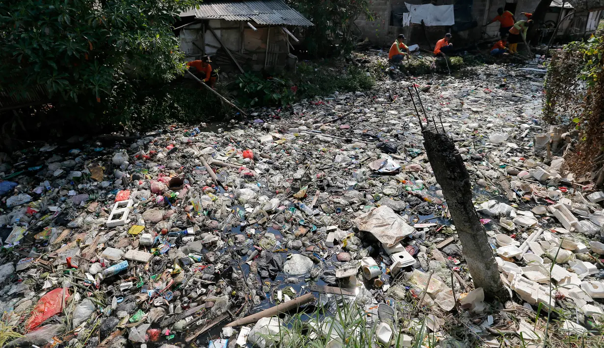 Petugas kebersihan membersihkan sampah di Kali Bahagia, Bekasi, Jawa Barat, Kamis (1/8/2019). Selain membuat pemandangan tidak sedap, sampah-sampah tersebut juga menimbulkan bau tak sedap dan dikhawatirkan menjadi sumber penyakit. (AP Photo/Tatan Syuflana)
