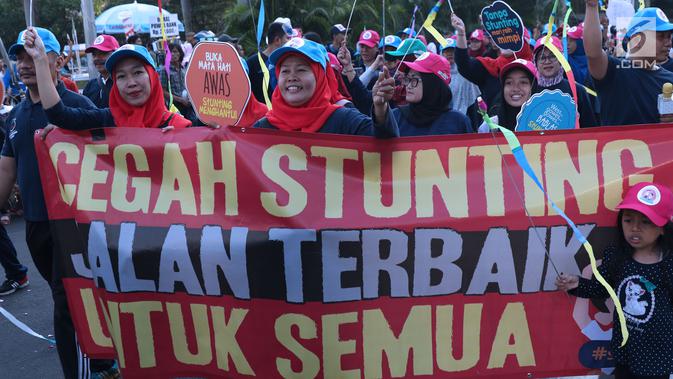 Peserta kampanye cegah stunting membawa spanduk saat berjalan di kawasan Bundaran Hotel Indonesia, Jakarta, Minggu (16/9). Peserta juga bakal memberikan penyuluhan tentang stunting ke masyarakat sekitar. (Liputan6.com/Helmi Fithriansyah)