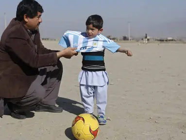 Bocah 5 tahun, Murtaza Ahmadi, asal Afghanistan menerima jersey  asli Lionel Messi lengkap dengan tanda tangan, sebelumnya bocah ini mengenakan jersey plastik nomor 10 dengan tulisan Lionel Messi. (REUTERS/Omar Sobhani)
