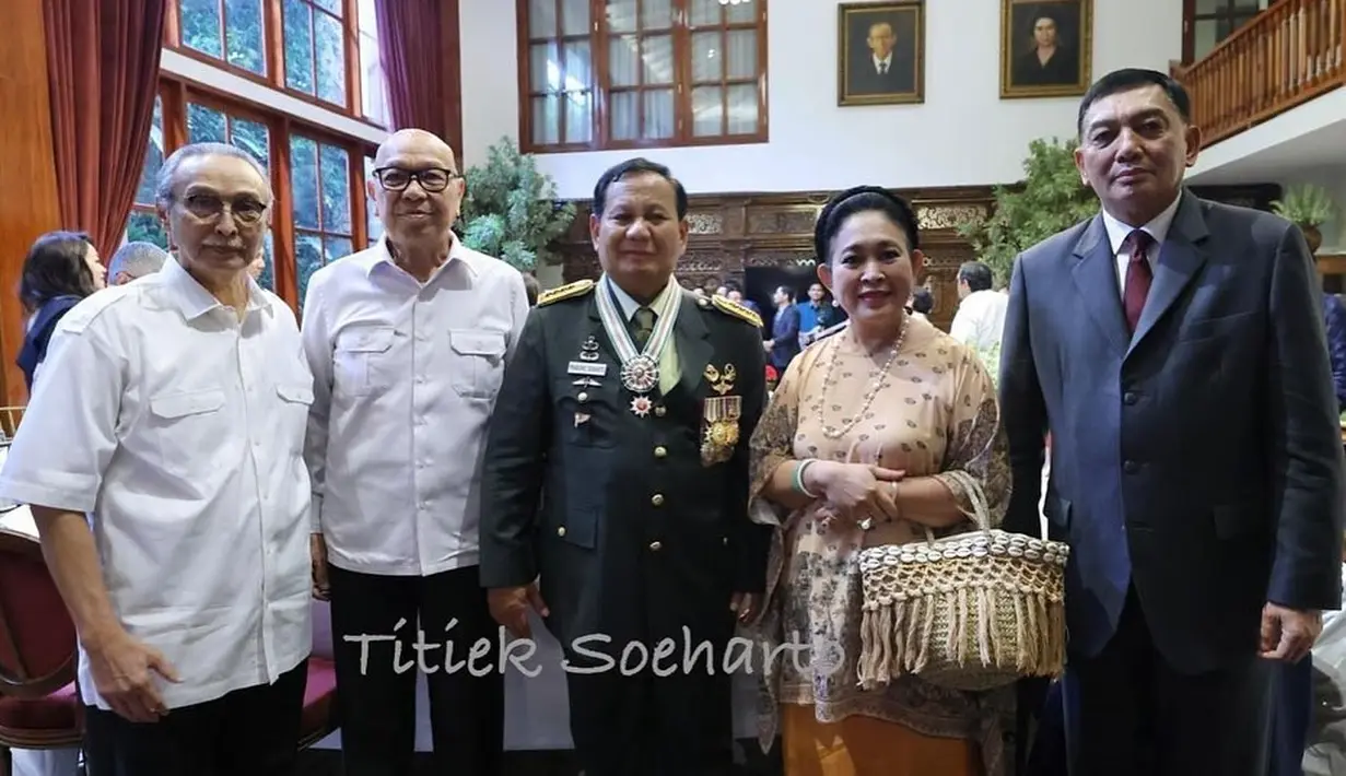 Titiek Soeharto mengenakan baju kurung creme motif hitam dengan rok kain oranye. Tas anyam dengan detail fringe jadi jinjingan Titiek selama belanja [@titieksoeharto]