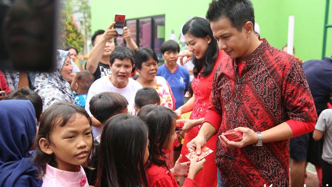 Delon dan istrinya, Aida Chanda, membagikan angpao Imlek kepada anak-anak (Kapanlagi/ Budy Santoso)