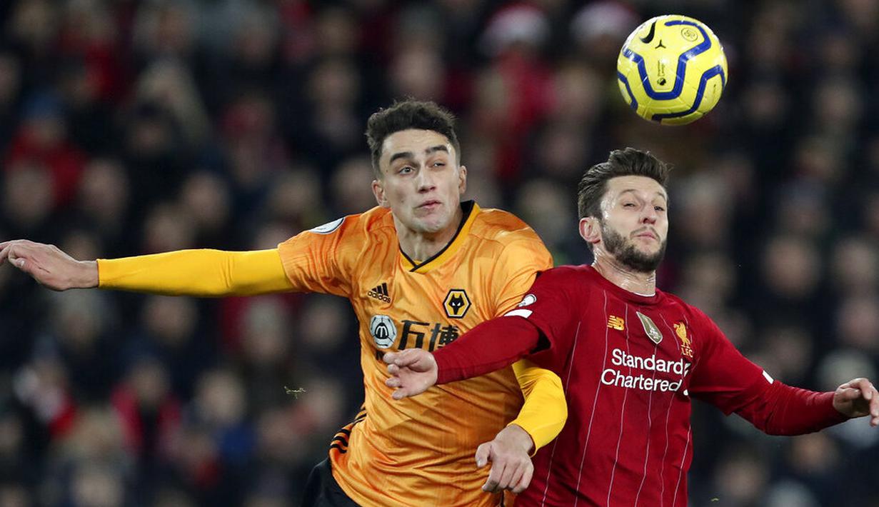 Gelandang Liverpool, Adam Lallana, berebut bola dengan pemain Wolverhampton Wanderers, Max Kilman, pada laga Premier League 2019 di Stadion Anfield, Minggu (29/12). Liverpool menang 1-0 atas Wolverhampton. (AP/Jon Super)