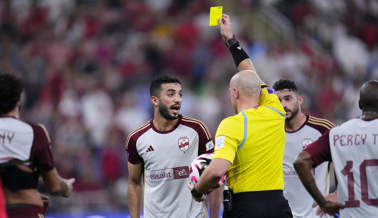 Wasit Szymon Marciniak memberi kartu kuning kepada bek Al Ahly, Mohamed Abdelmonem saat menghadapi Fluminense pada laga semifinal Piala Dunia Klub 2023 di King Abdullah Sports City Stadium, Arab Saudi, Selasa (19/12/2023) dini hari WIB. (AP Photo/Manu Fernandez)