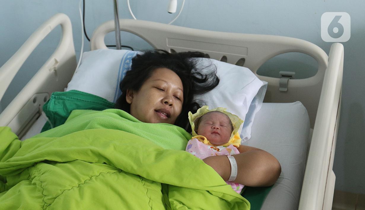 Regina (43) memeluk bayinya Glowy Lidwina usai menjalani proses persalinan di RSUD Pasar Minggu, Jakarta, Kamis (20/2/2020). Bayi perempuan dari pasangan Regina dan Andre (47) bernama Glowy Lidwina lahir secara sesar di tanggal 20 bulan 02 tahun 2020 atau 20-02-2020. (Liputan6.com/Herman Zakharia)