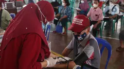 Petugas medis mengecek kesehatan seorang lansia sebelum melakukan vaksinasi Covid-19 di Gor Total Persada, Kota Tangerang, Selasa (8/6/2021). Vaksinasi tersebut untuk melindungi mereka dari Covid-19 yang tengah mewabah. (Liputan6.com/Angga Yuniar)