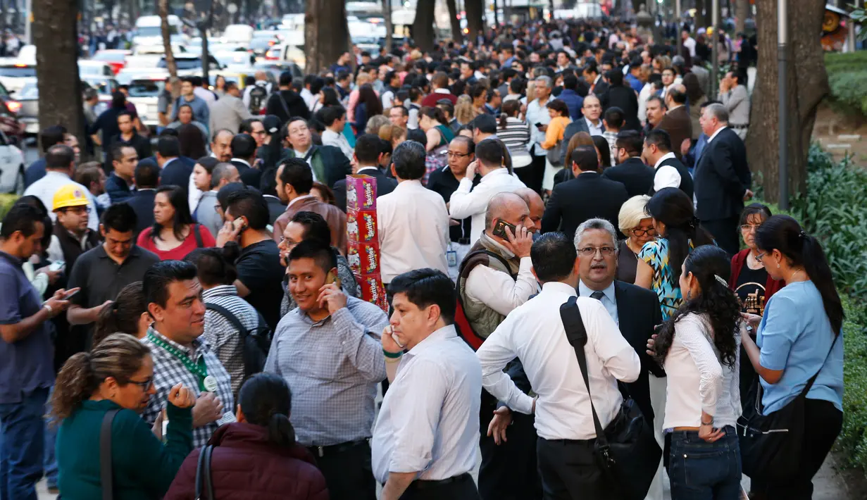 Orang-orang berkumpul diluar gedung di sepanjang Reforma Avenue setelah terjadi gempa di Mexico City, Meksiko (16/2). Pusat gempa berada di lokasi 37 kilometer timur laut Pinotepa de Don Luis, Oaxaca. (AP Photo/Marco Ugarte)