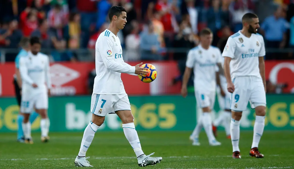 Striker Real Madrid Cristiano Ronaldo membawa bola ke tengah lapangan usai gawangnya kebobolan dari Girona saat pertandingan La Liga di stadion Montilivi di Girona, Spanyol (29/10). (AP Photo/Manu Fernandez)