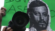 Seorang  memegang kamera dan foto Ruben Espinosa Ruben saat menggelar protes di monumen Kemerdekaan di Mexico City, Meksiko, Minggu (2/8/2015).   Ruben Espinosa adalah seorang wartawan investigasi untuk majalah Proceso. (REUTERS/Henry Romero)